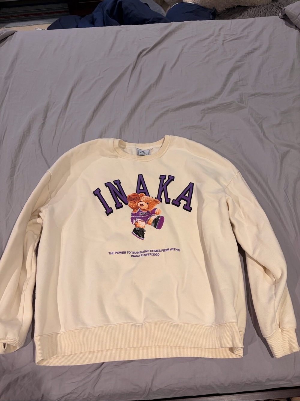 Inaka Power Cream Crewneck with Purple Lettering and Multicolor Bear Graphic